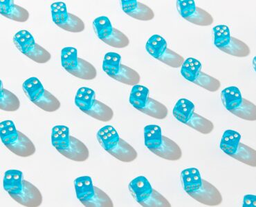 Blue dice representing repeated random trials in a Monte Carlo simulation.