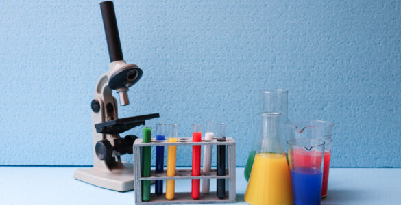 Laboratory glassware with colored liquids arranged on a chemistry lab table