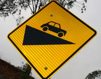 A retroreflective road sign photographed in daylight, showing how warning signs are built to return headlight beams at night.