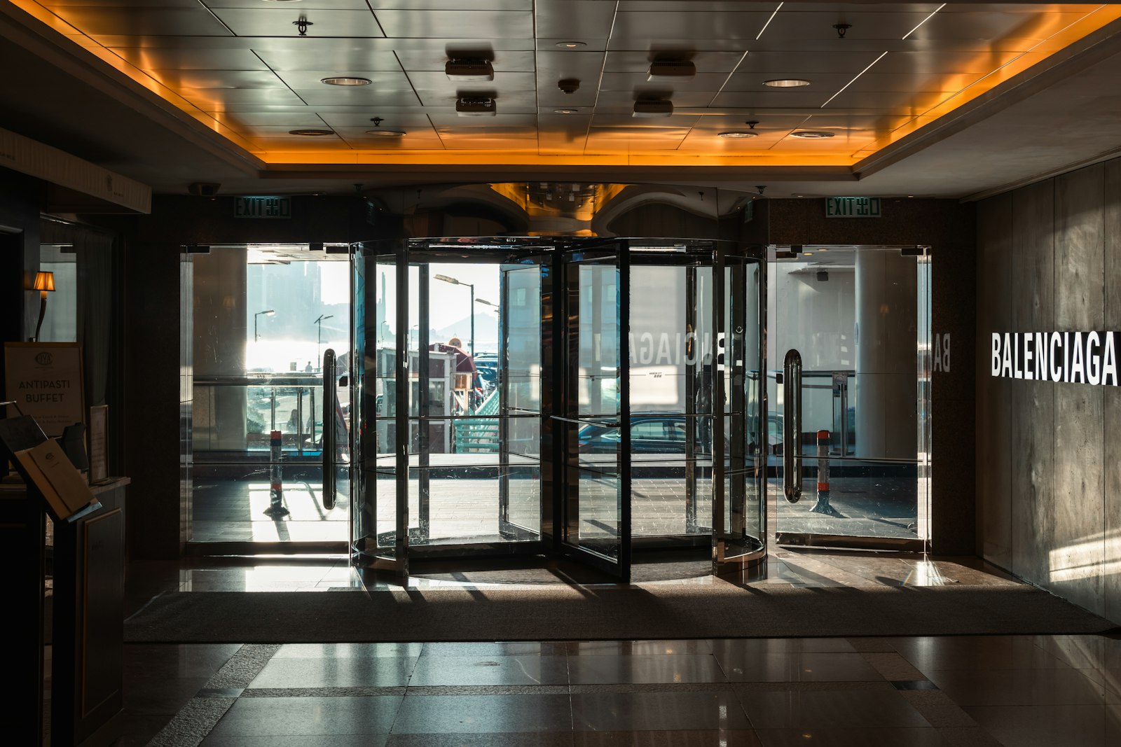 A glass entrance with revolving and swinging doors showing how different public doors guide foot traffic.