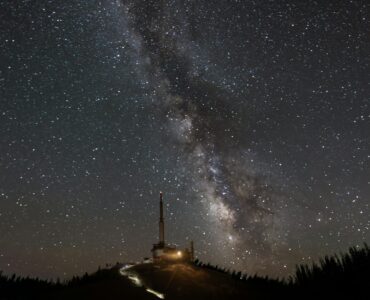 An observatory beneath the Milky Way, representing a wide sky survey scanning the night sky