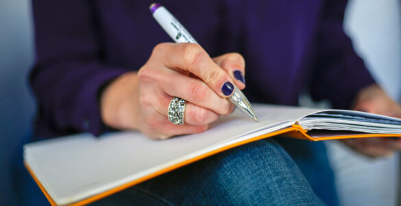 A student reviews assignment notes while checking criteria before revising work.
