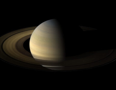 Saturn and its bright rings seen with several small moons nearby.
