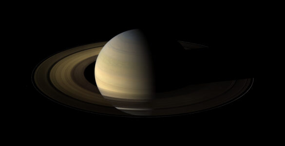 Saturn and its bright rings seen with several small moons nearby.