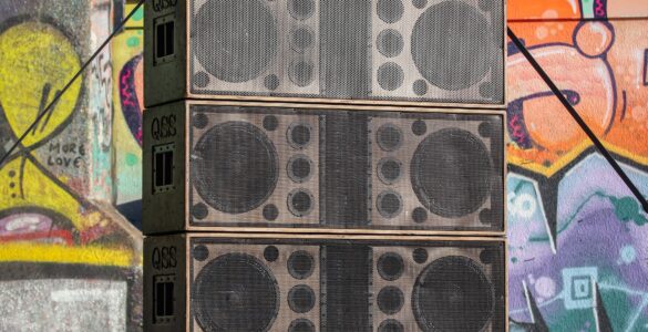 Large speaker stacks facing a crowd at an outdoor concert