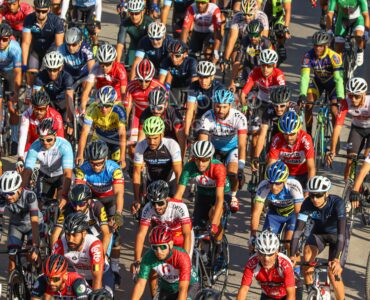 A large group of road cyclists riding closely together in a race