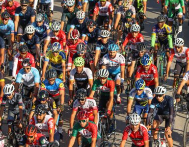 A large group of road cyclists riding closely together in a race