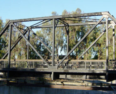 A truss bridge with diagonal beams forming triangles across its side.