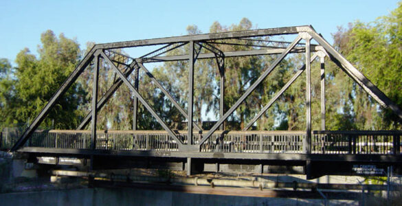 A truss bridge with diagonal beams forming triangles across its side.