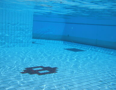 An underwater view in a swimming pool showing how water surrounds sound sources differently than air.