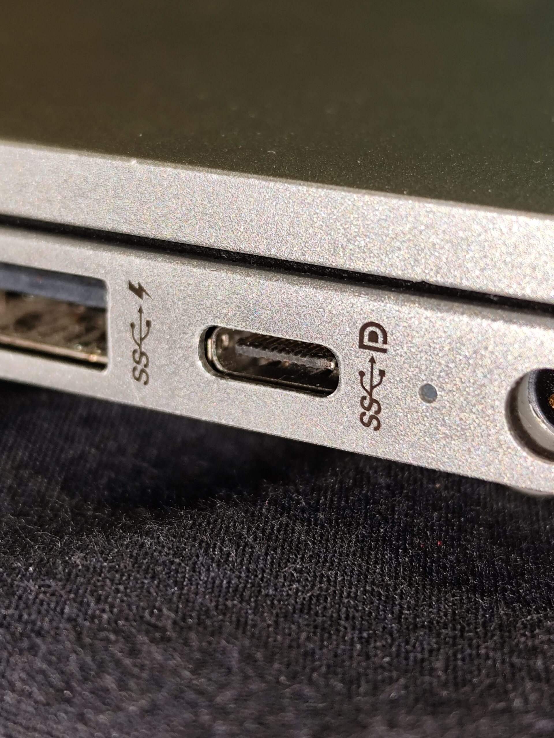 A USB-C cable plugged into a laptop port used for charging and data transfer