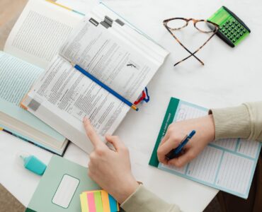 Open math books, notes, a pencil, and a calculator used while studying arithmetic sequences.