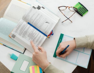 Open math books, notes, a pencil, and a calculator used while studying arithmetic sequences.