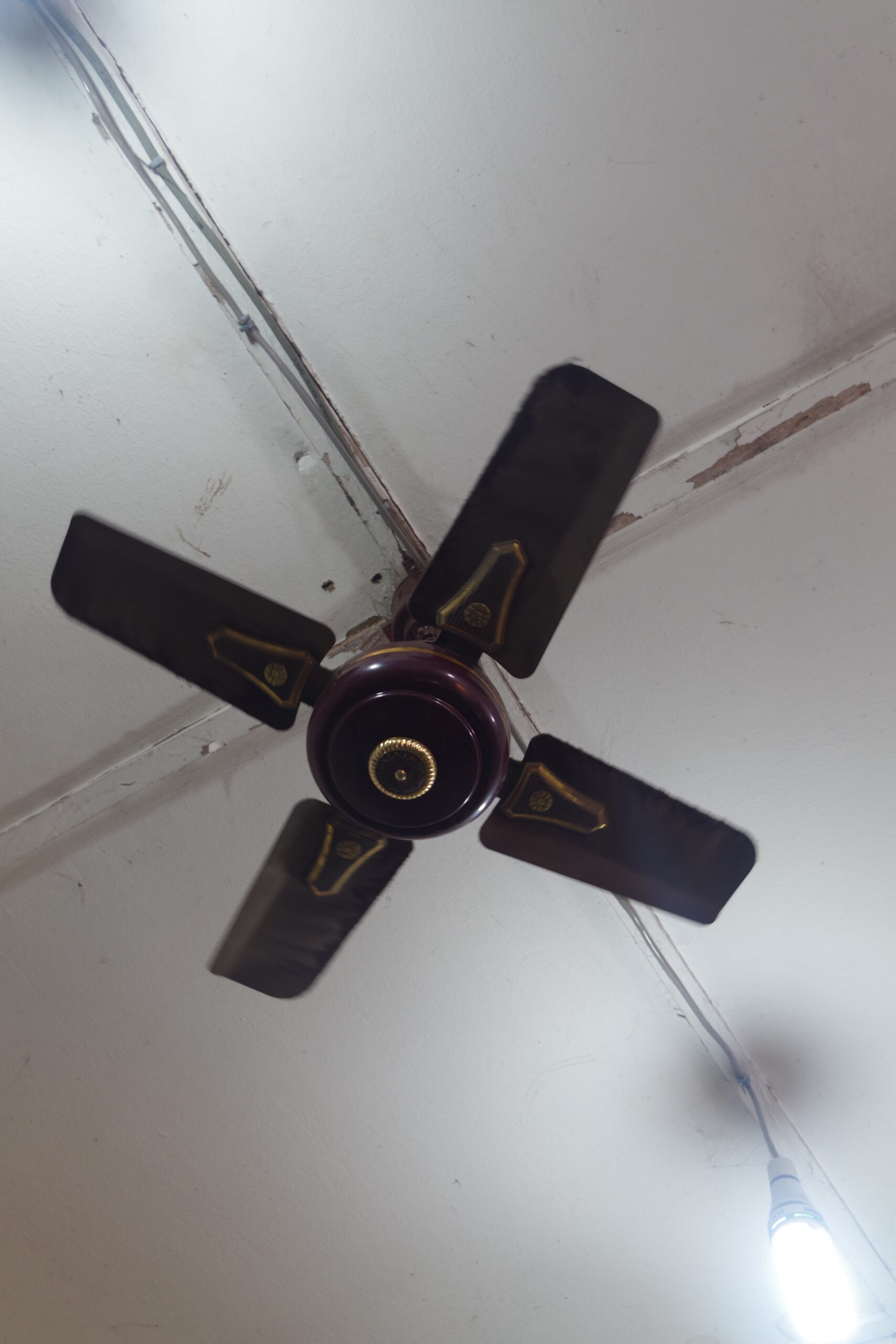 A ceiling fan moving indoor air, showing why moving air can make the same temperature feel cooler.