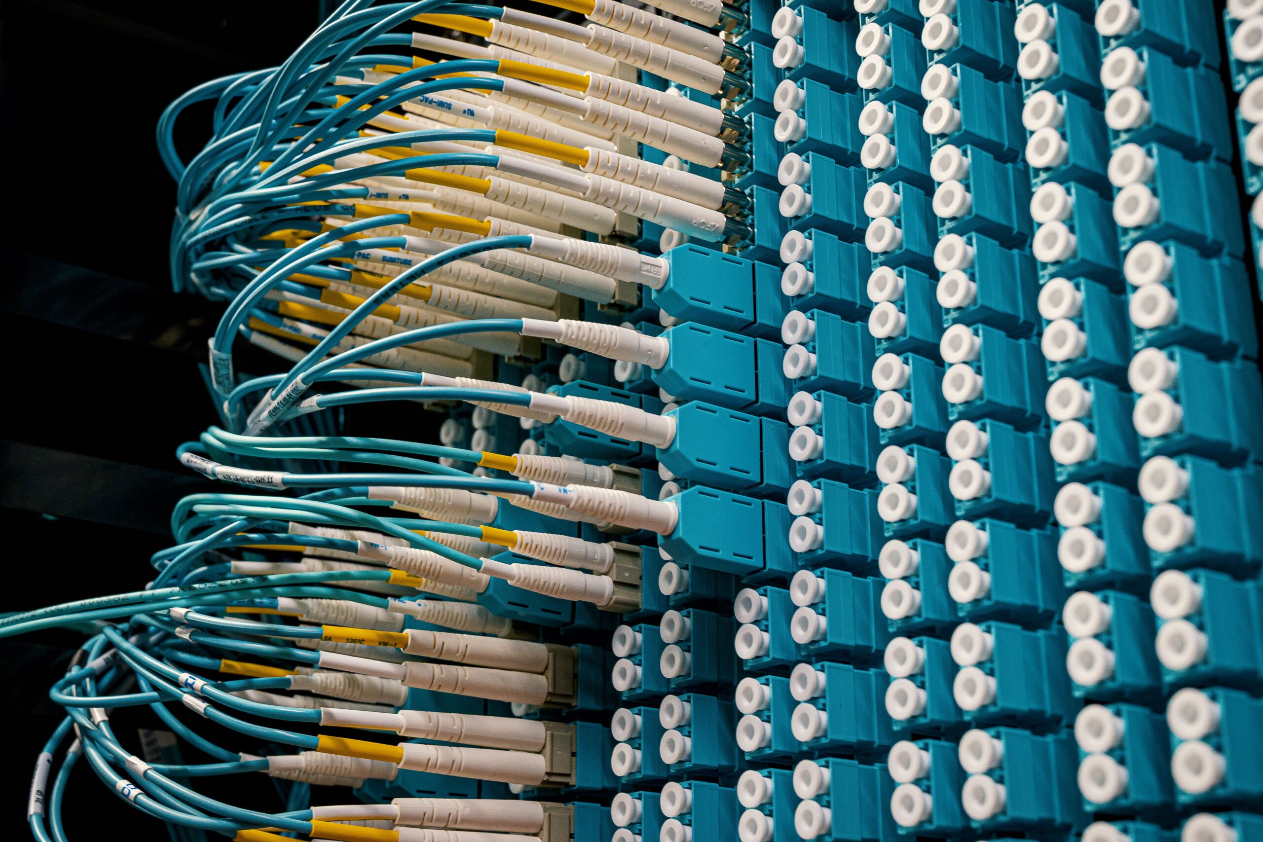 Fiber optic cables connected to network equipment that helps cloud services move data between users and servers.