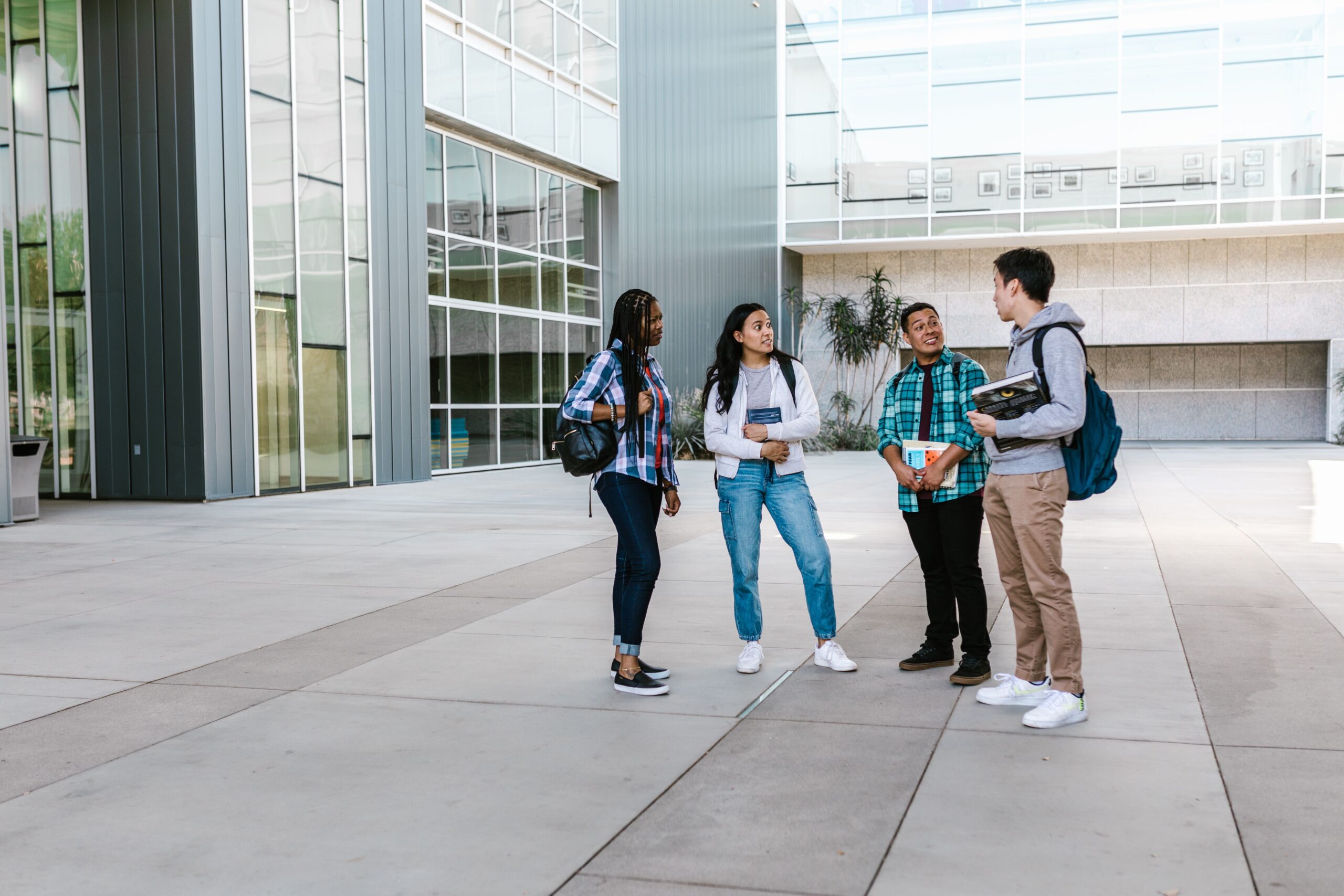 College students discussing academic support options together while preparing questions for a campus office.