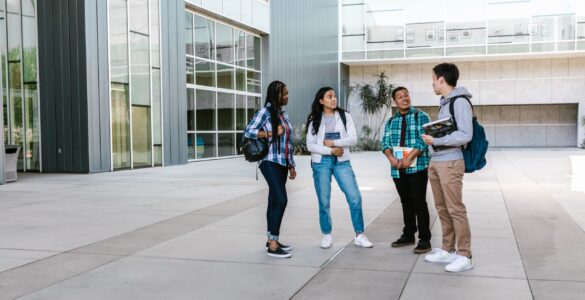 College students walking near a campus building while planning how to request academic accommodations before classes start.