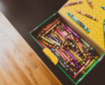 A box of colorful crayons ready for drawing, showing the wax sticks used to leave color on paper.