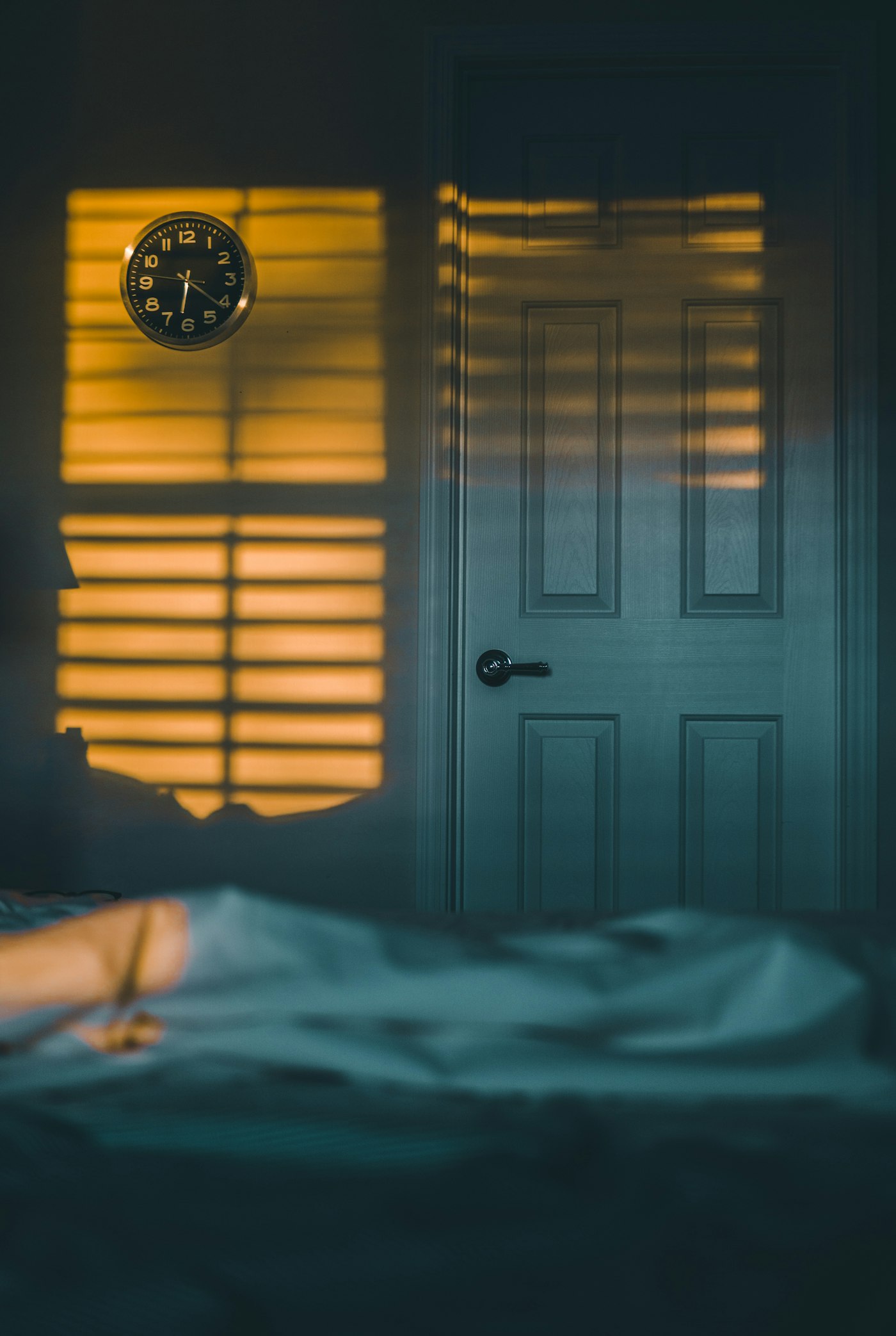 An alarm clock beside a bed in morning light, representing how clock changes can affect wake-up routines