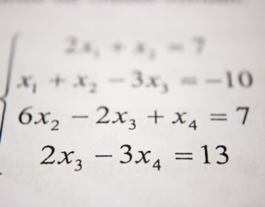 A student works through algebra steps on a whiteboard while practicing the distributive property.