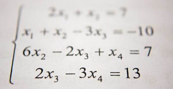 A student works through algebra steps on a whiteboard while practicing the distributive property.