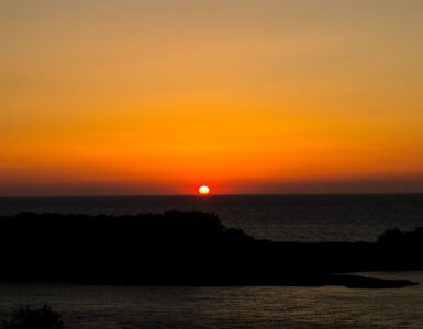 The Sun sits on the horizon at sunrise, showing why the visible edge matters when measuring daylight.