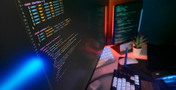 Programming code displayed on screens, representing error-correcting codes that help digital messages survive noise.