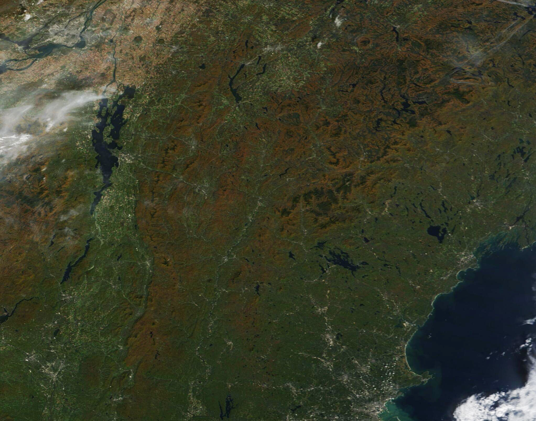 A satellite view of fall colors across New England showing how seasonal leaf changes spread across a region.