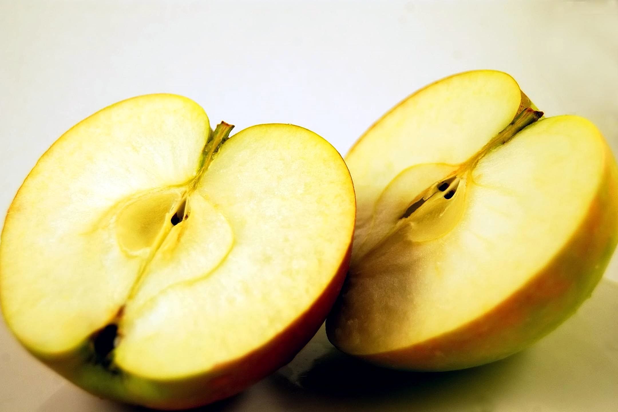 Freshly cut apple halves showing pale exposed fruit flesh before browning becomes visible.
