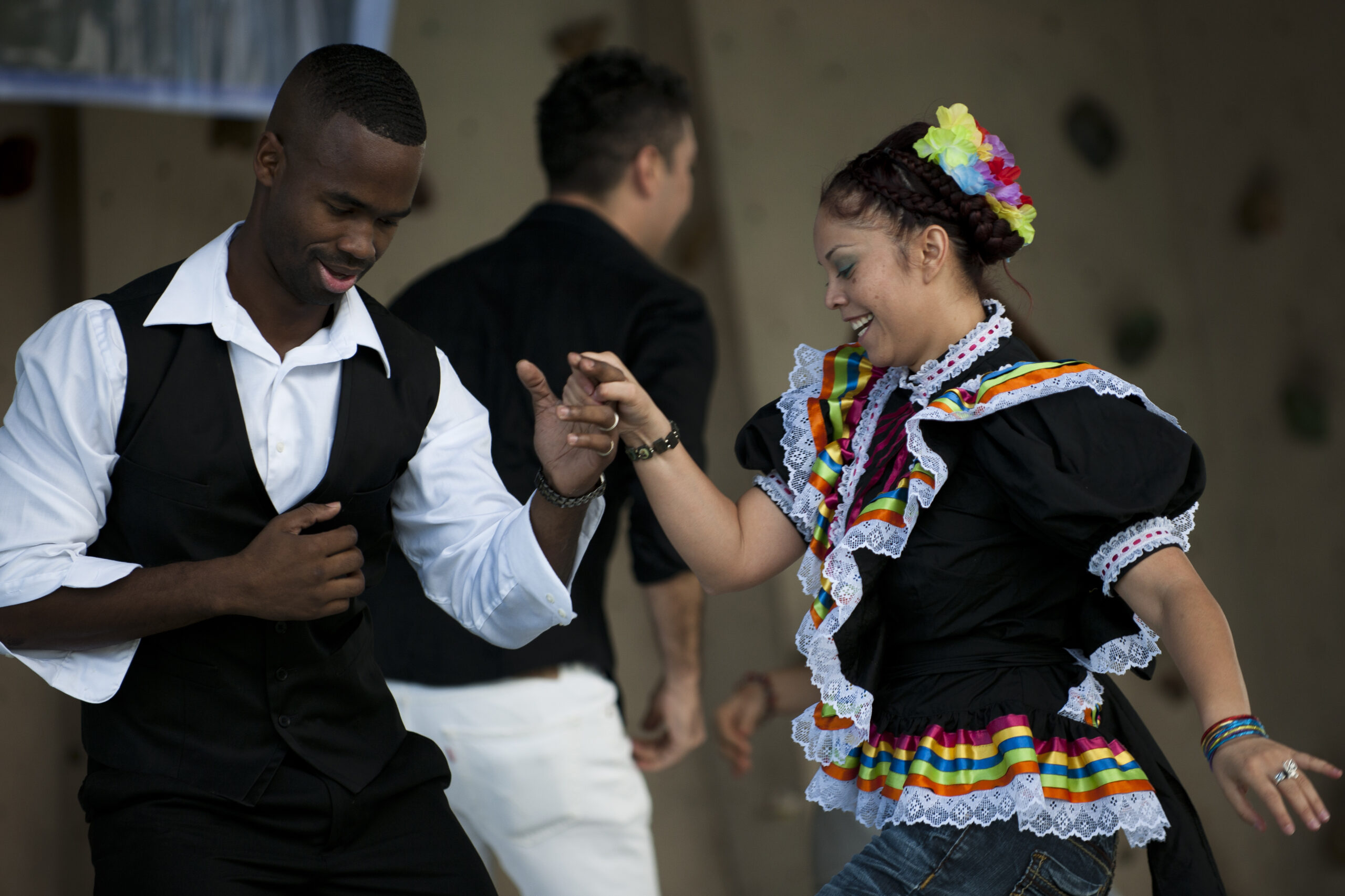 Dancers perform during a Hispanic Heritage Month finale festival with an audience nearby.