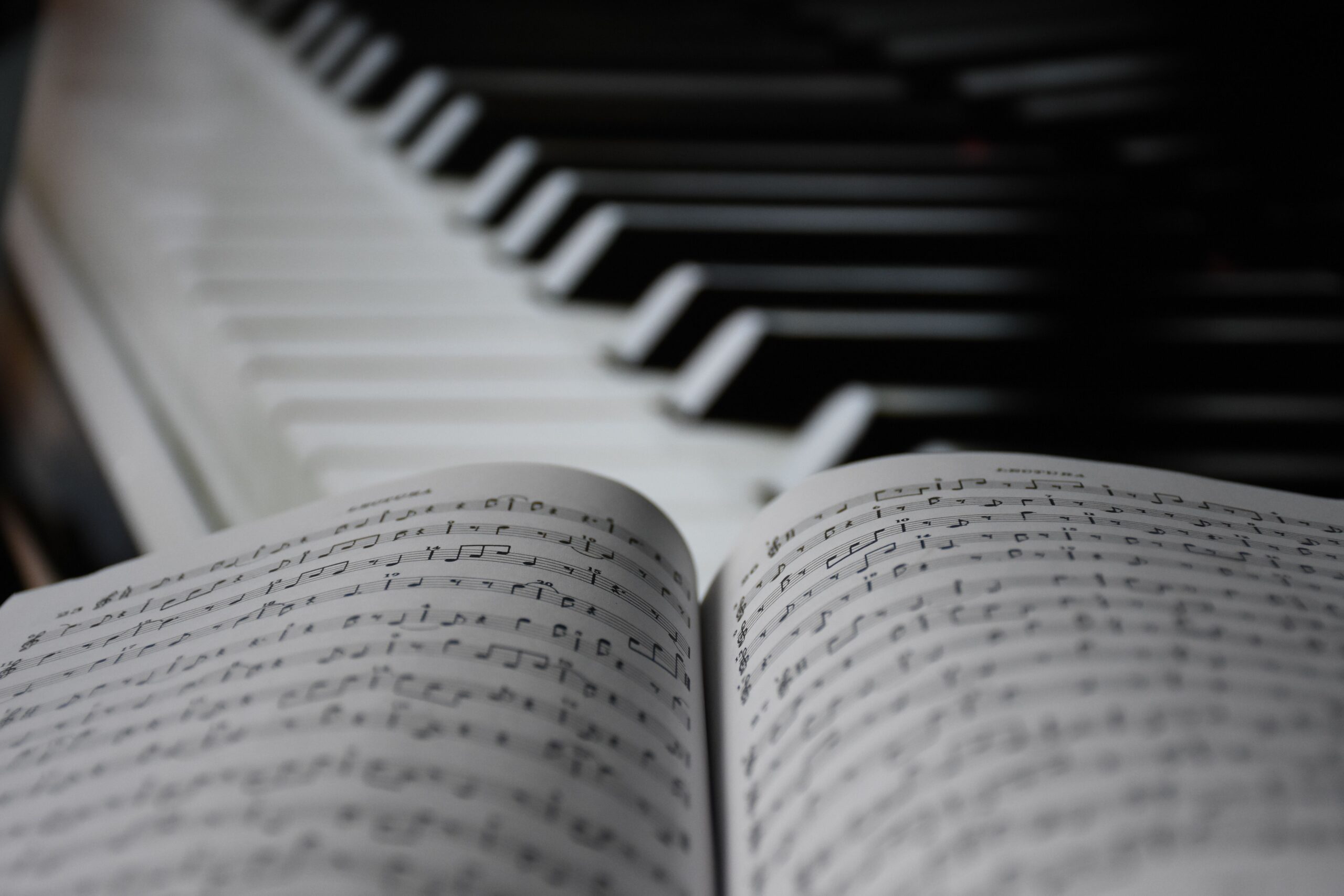 Piano keys beside open sheet music for practicing steady tempo with a metronome.