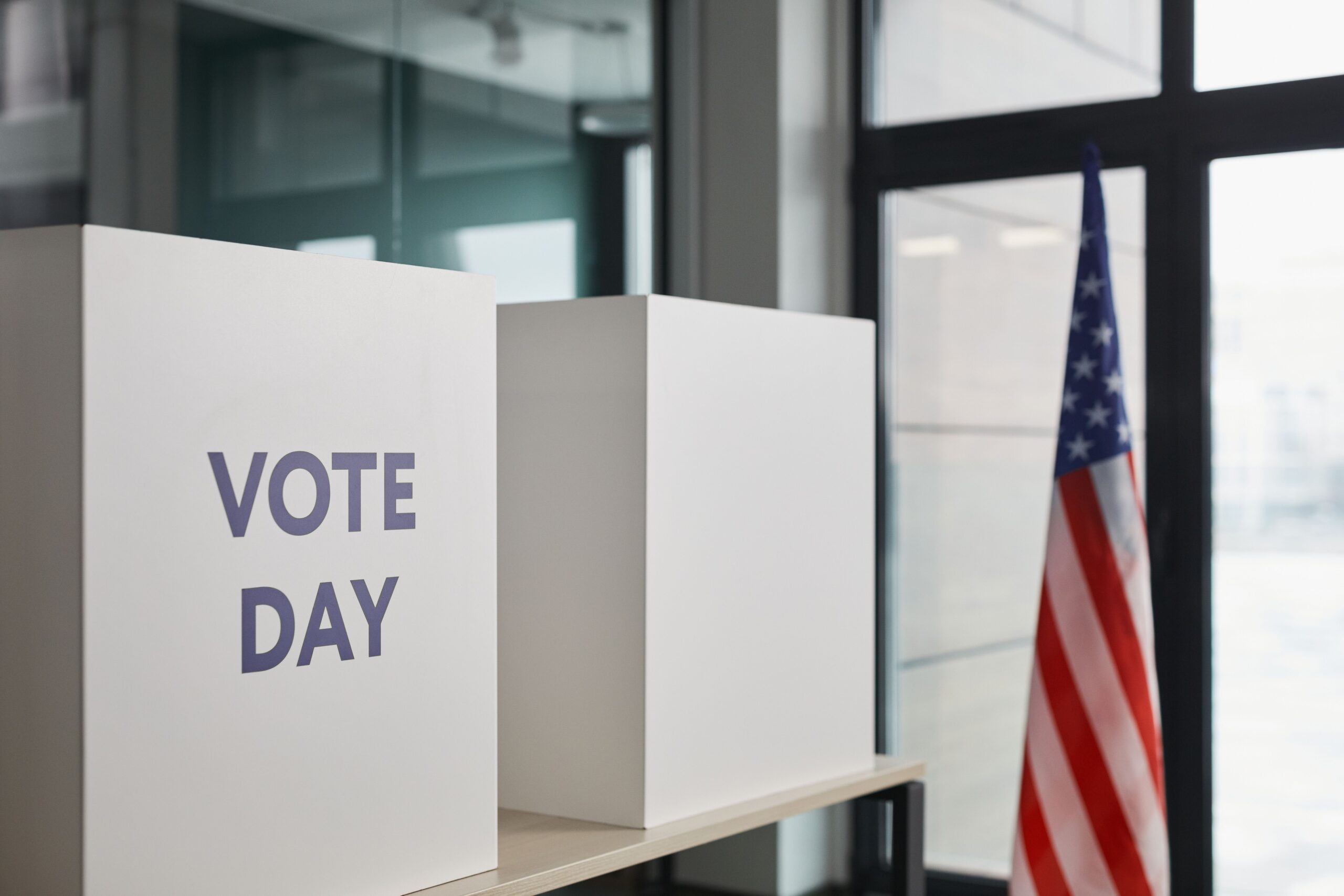 Voting booths and an American flag set up at a polling place.