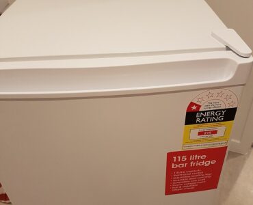 A compact refrigerator in a small room where airflow around the appliance affects cooling