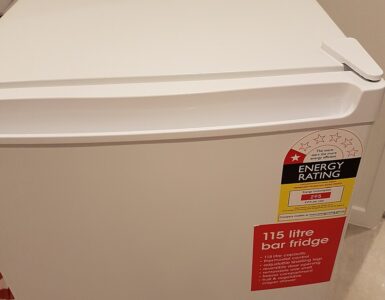 A compact refrigerator in a small room where airflow around the appliance affects cooling