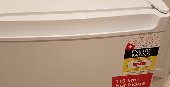 A compact refrigerator in a small room where airflow around the appliance affects cooling