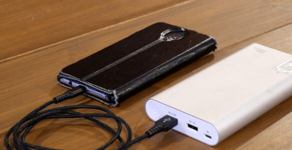 A smartphone charging from a portable power bank, representing how rechargeable batteries lose capacity over time.