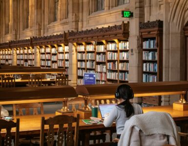 A student studies quietly in a library after using reading strategies to understand a text.