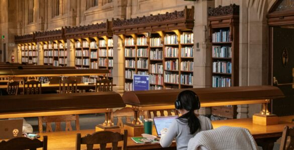 A student studies quietly in a library after using reading strategies to understand a text.