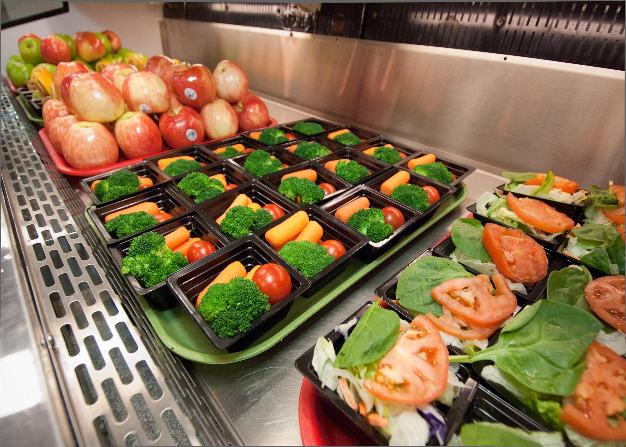 Fresh fruit, salads, and vegetables displayed for a school lunch program.