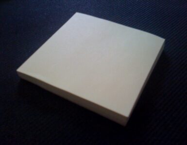 A stack of yellow sticky notes showing the everyday paper surface used in removable adhesive chemistry.