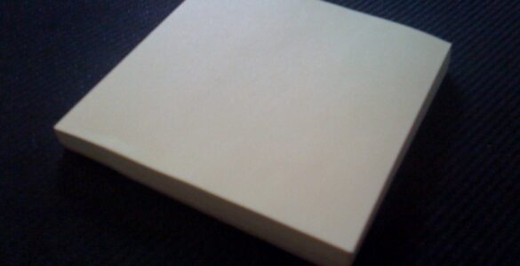 A stack of yellow sticky notes showing the everyday paper surface used in removable adhesive chemistry.