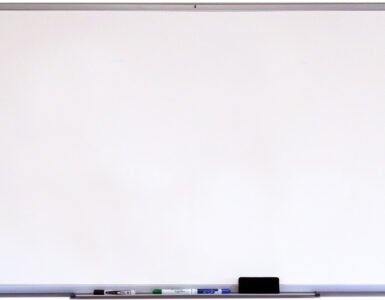 A whiteboard with dry-erase markers and an eraser ready for classroom writing.