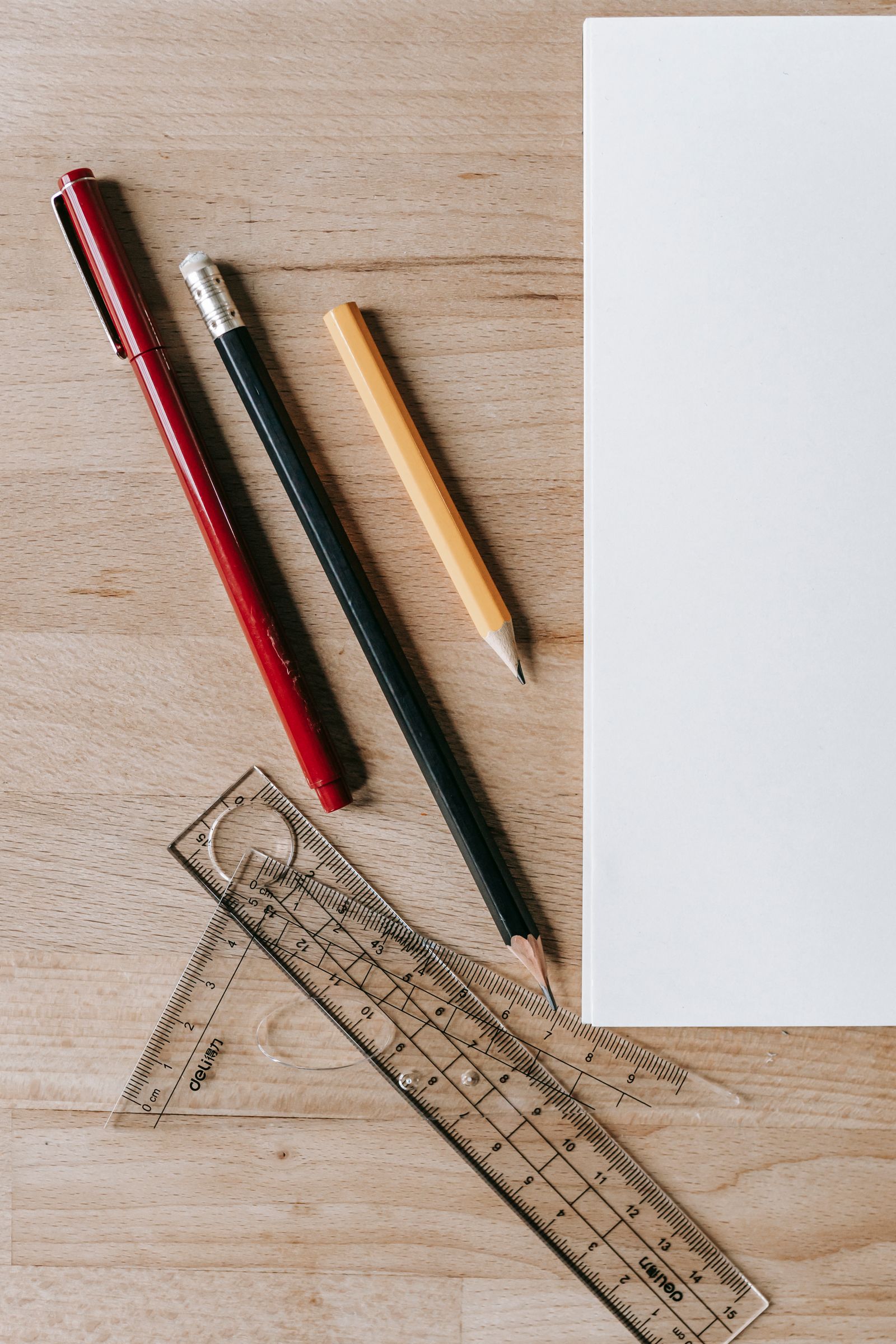 A blank sheet of paper beside rulers and pencils, representing the measurements and aspect ratio of A4 paper.