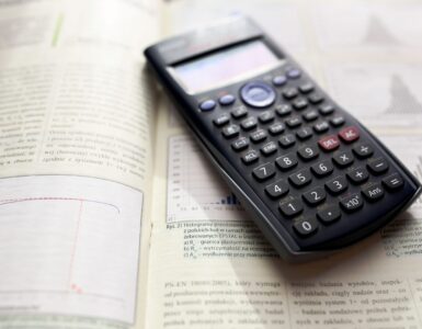 A scientific calculator on an open calculus textbook for working through optimization problems.