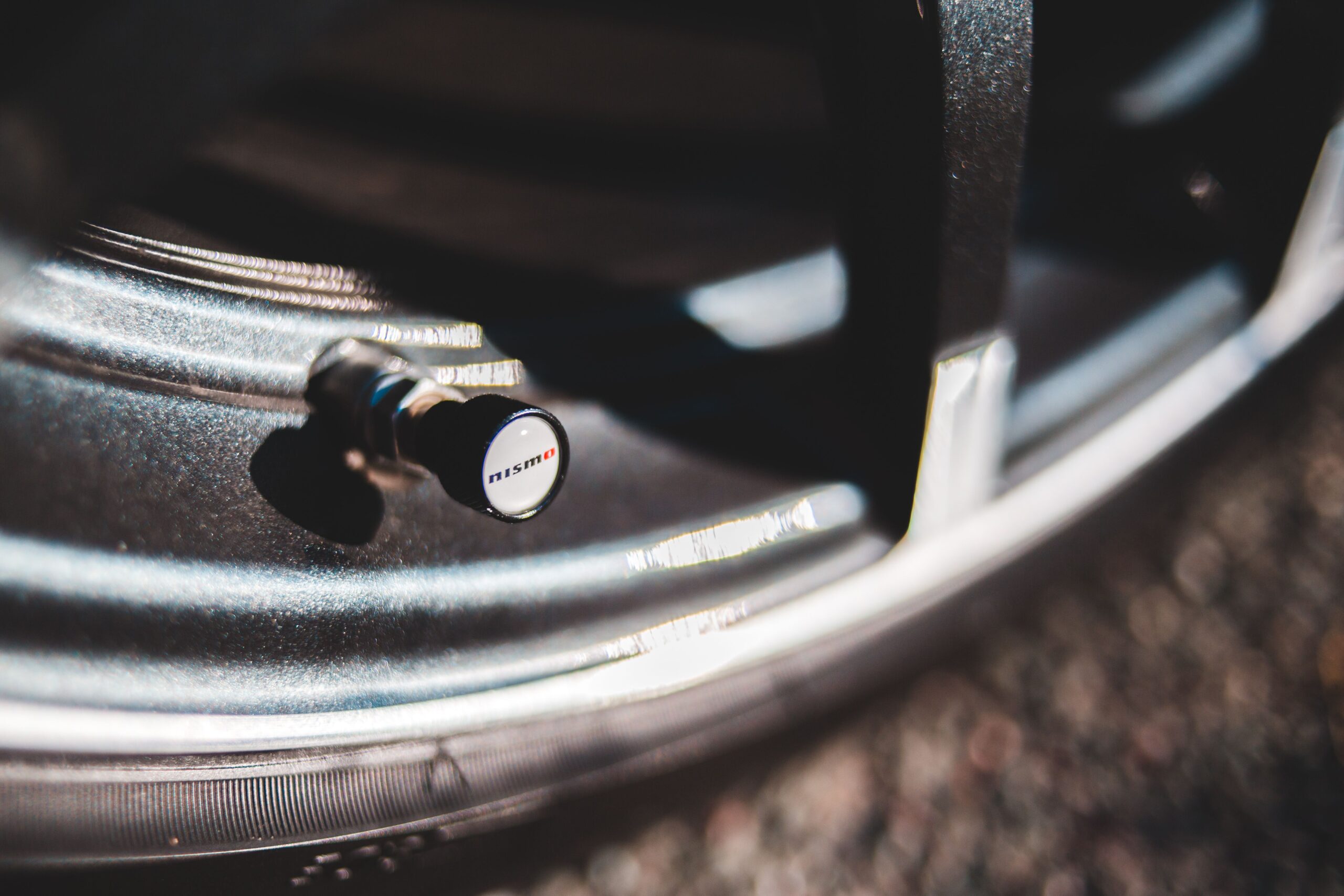 Close-up of a valve stem on a car wheel used to measure tire pressure