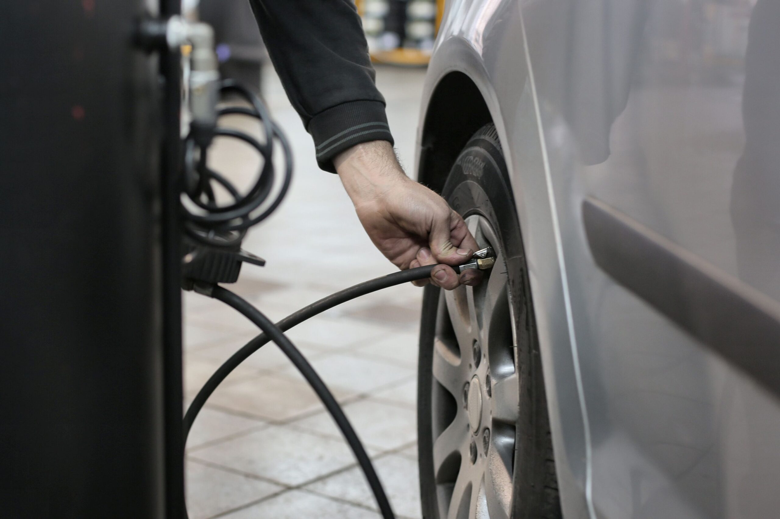 Mechanic using an air hose to check and inflate a car tire