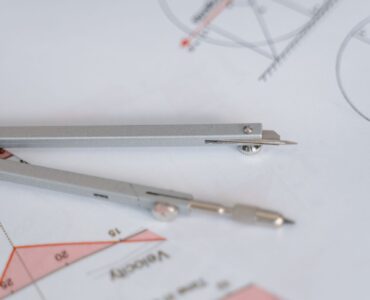 A compass and ruler on a circular geometry diagram used to study radius and area.