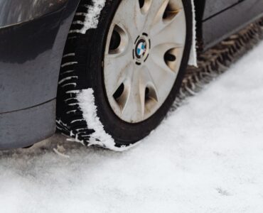 Close-up of a car tire resting on a snow-covered road