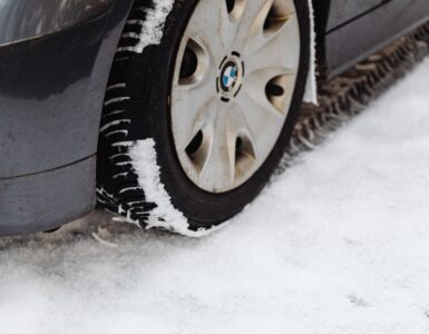 Close-up of a car tire resting on a snow-covered road