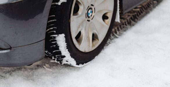 Close-up of a car tire resting on a snow-covered road